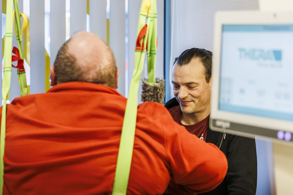 Patient vor dem Therapiebildschirm, Therapeut daneben