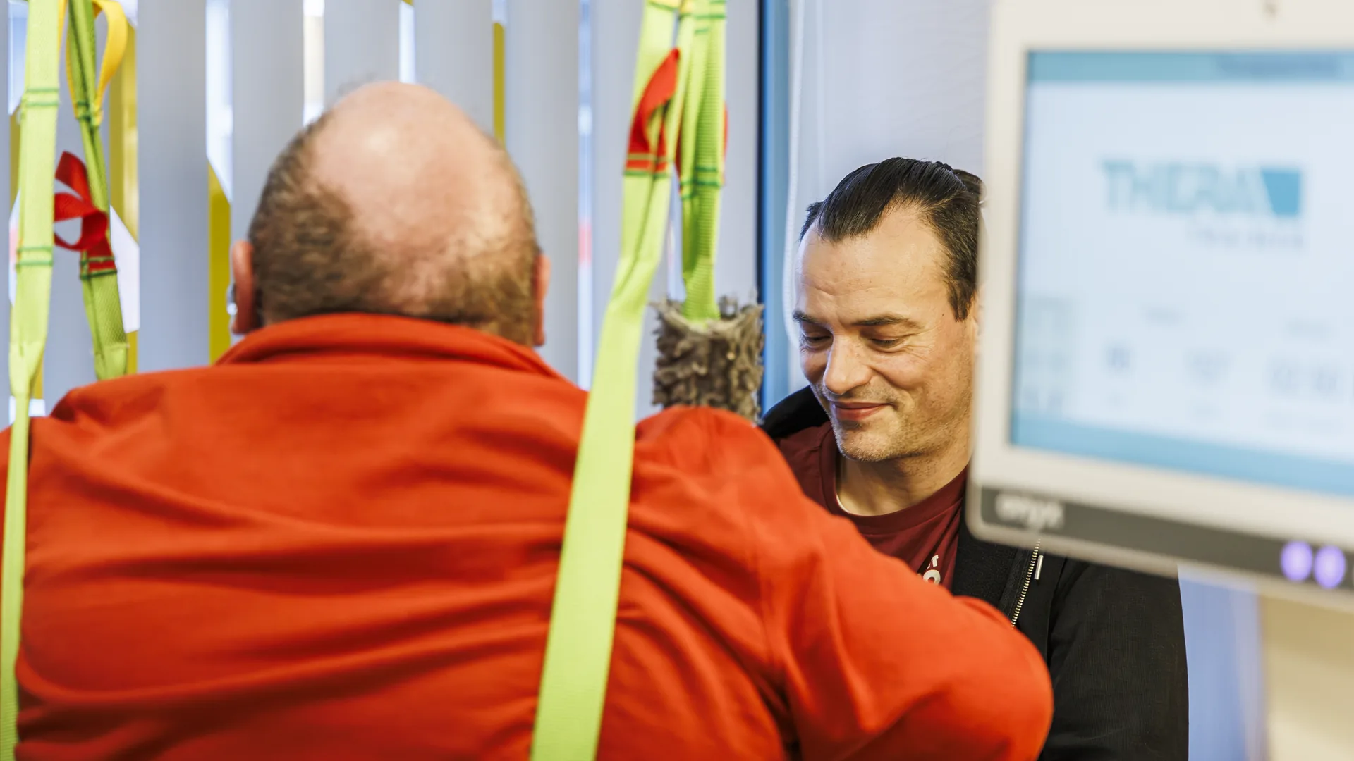 Patient vor dem Therapiebildschirm, Therapeut daneben